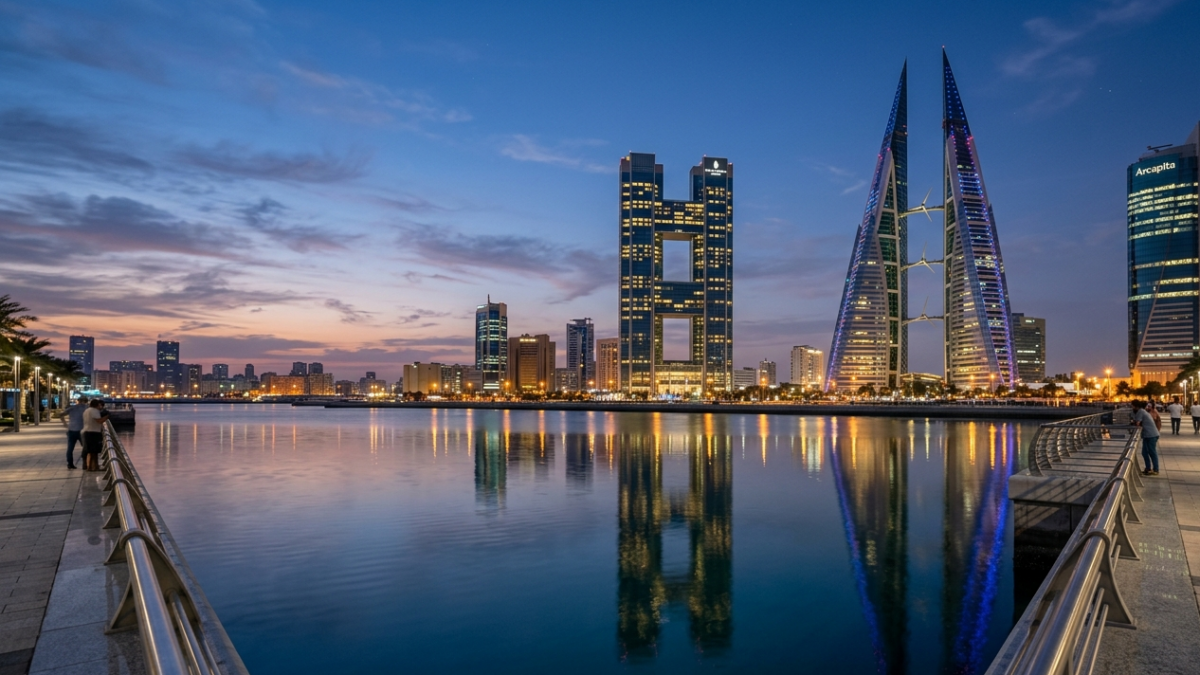 Modern illuminated commercial towers of Bahrain Bay reflecting on the waterfront during twilight.