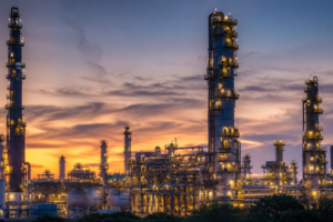 Exterior of a large-scale oil refining complex operating at dusk in Saudi Arabia.